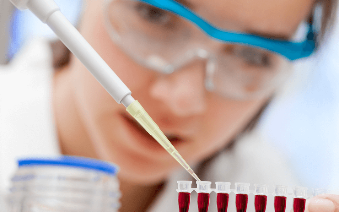 Lab tech using a pippet to drop liquid into tubes